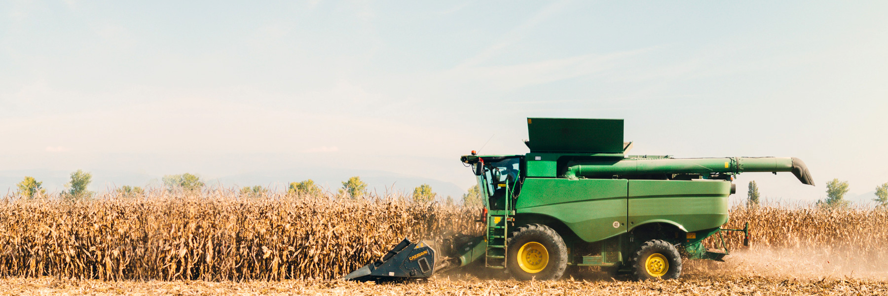 combine in field at sunrise