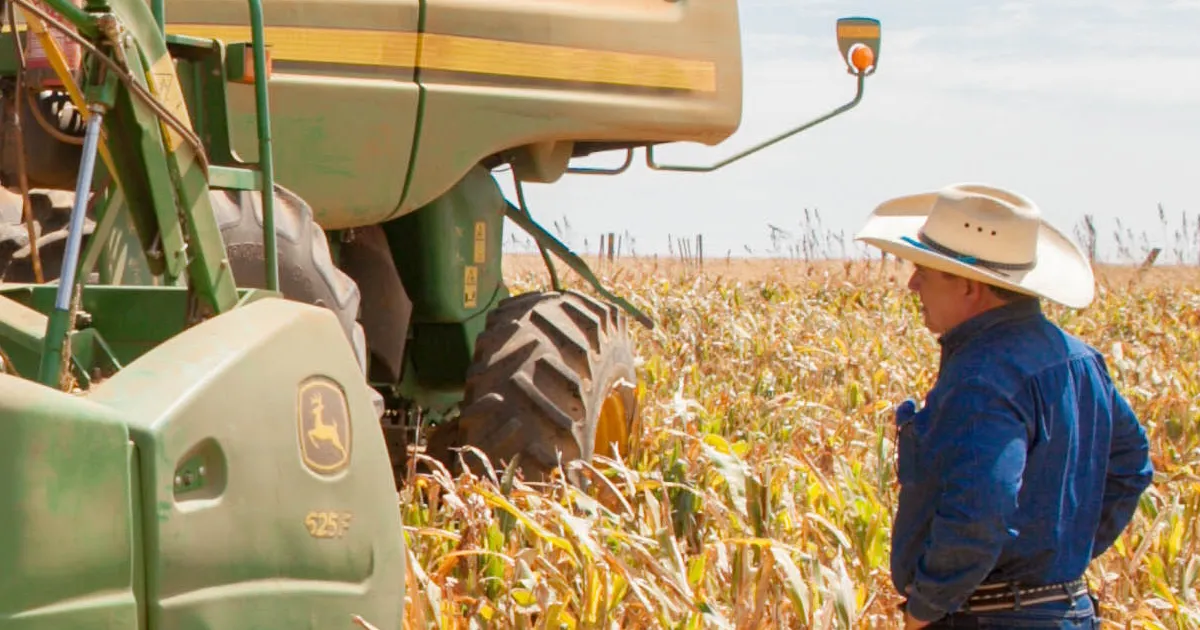 man inspecting combine